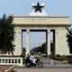 People on a motorcycle drive past the Black Star Gate in Accra, Ghana, on July 14, 2017.